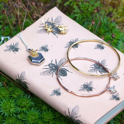 set of bee jewellery on a book outside