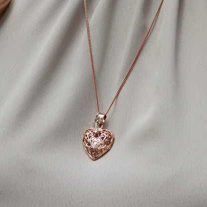close up of model wearing heart locket necklace in rose gold