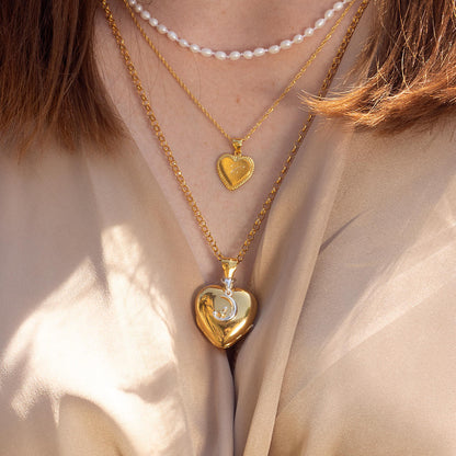 model wearing gold heart shaped locket with moon charm