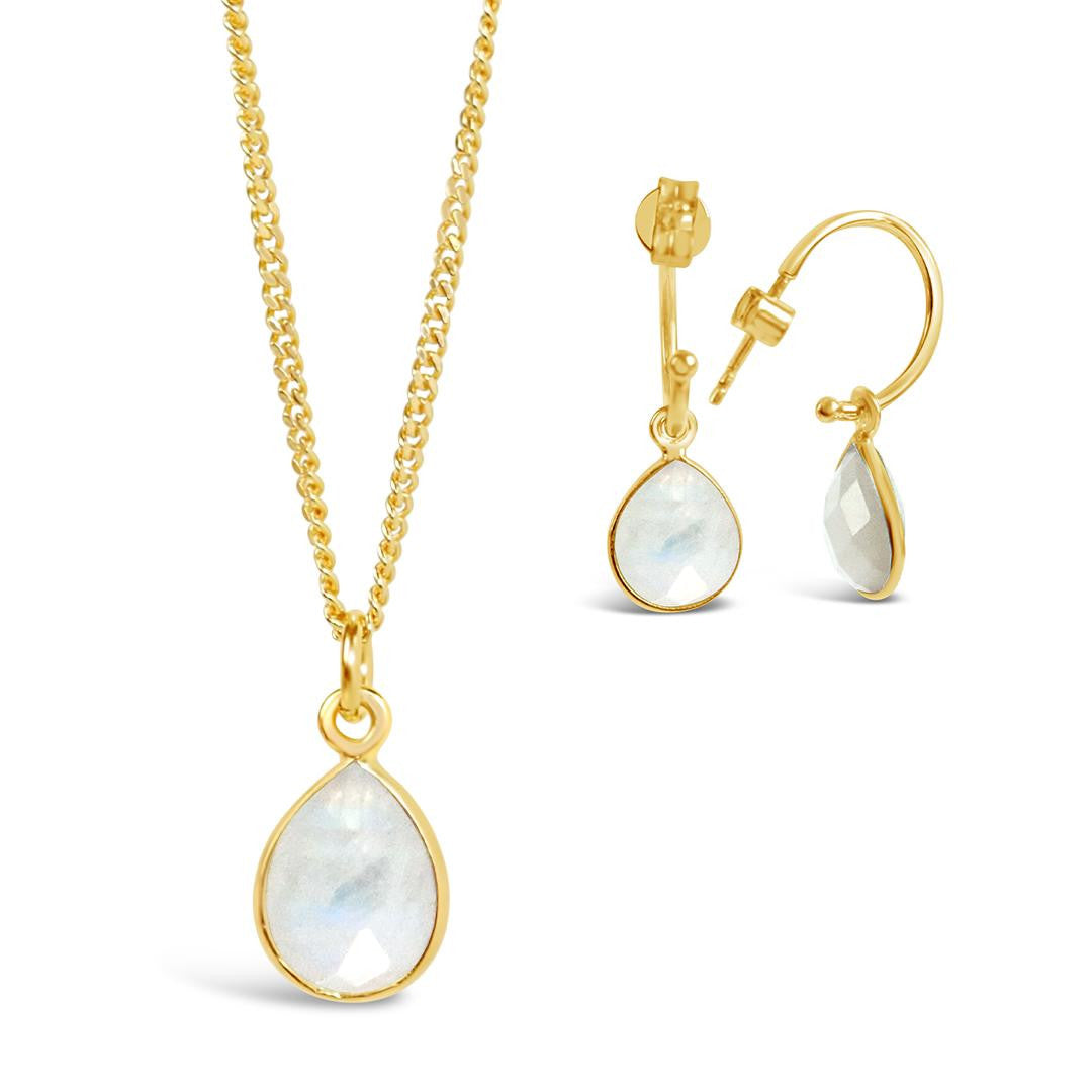 white quartz charm necklace and drop hoop earrings in gold on a white background