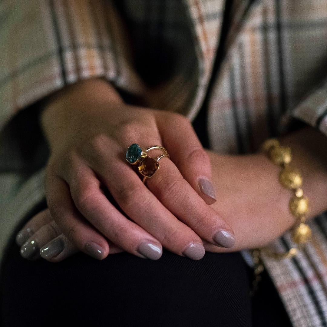 close up of model wearing two cocktail rings with different gemstones