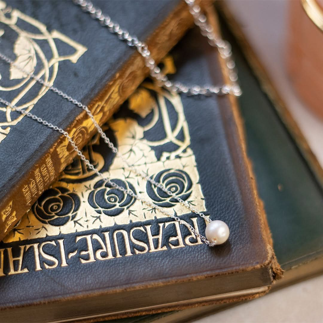 pearl chain necklace in ivory silver on top of books