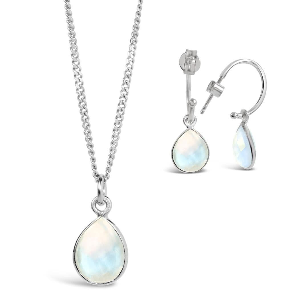 moonstone charm necklace and drop hoop earrings in silver on a white background