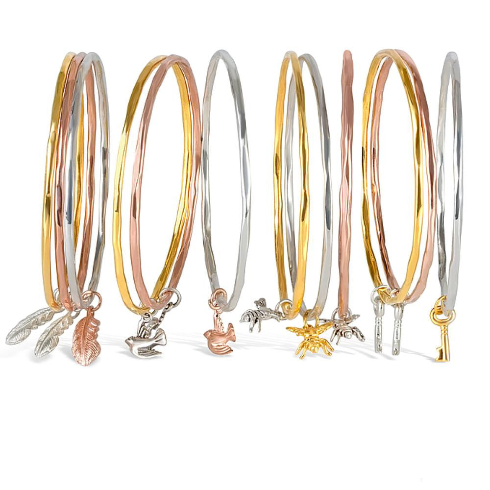 rose gold, gold and silver bee bangles on a white background