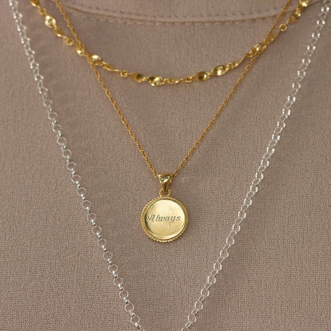 close up of model wearing engraved disc necklace 
