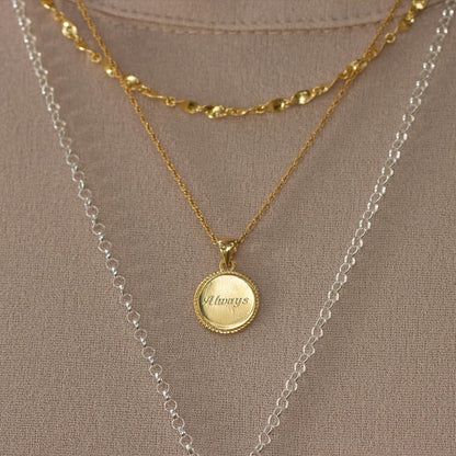 close up of model wearing engraved disc necklace 