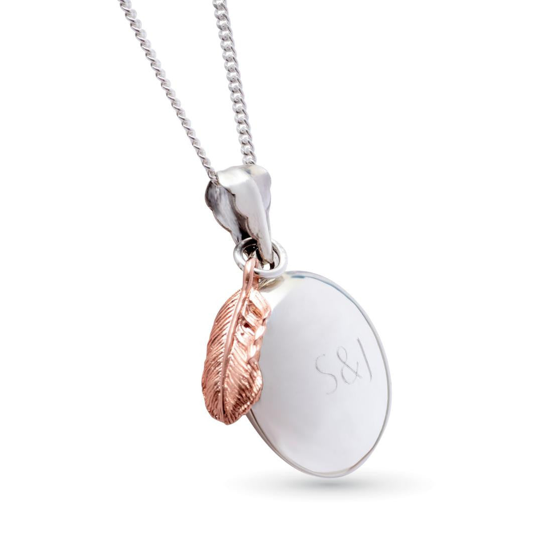 white gold feather locket with rose gold charm attached and locket engraved with message