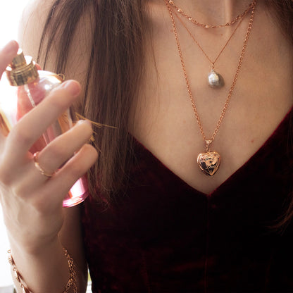 model in black dress wearing rose gold heart shaped locket with engraved message