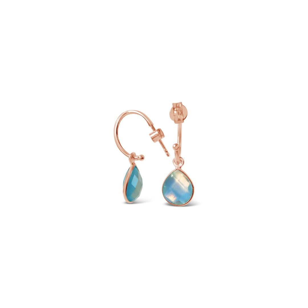 blue topaz drop hoop earrings in rose gold on white background