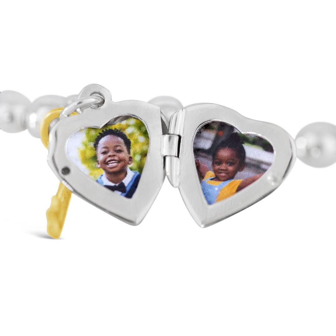 closeup of photos inside heart locket bangle in silver