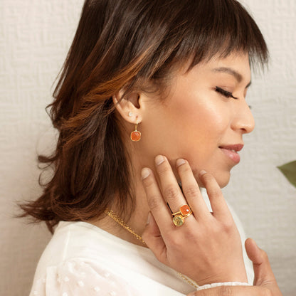 model wearing carnelian cocktail ring and luminous earrings