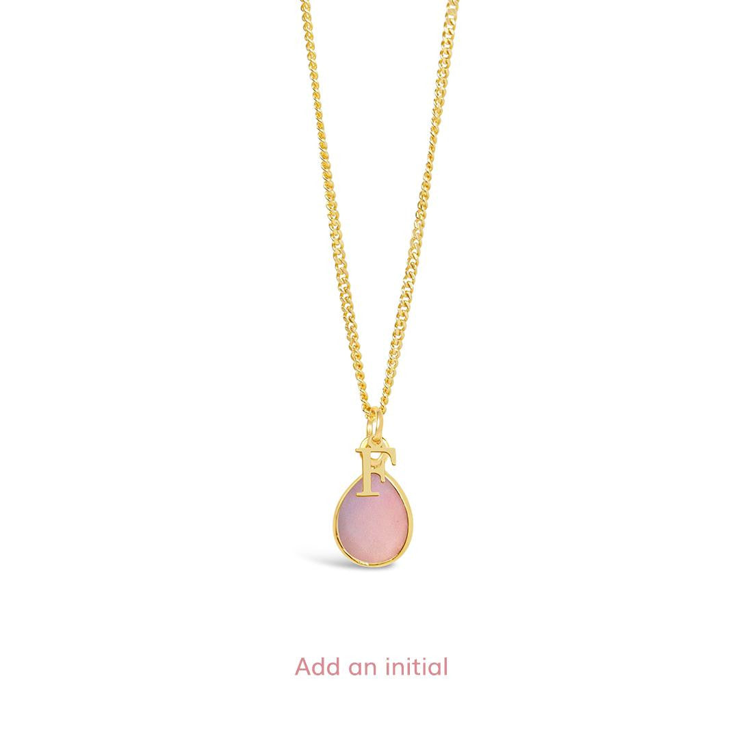 pink opal charm necklace in gold with initial charm on a white background