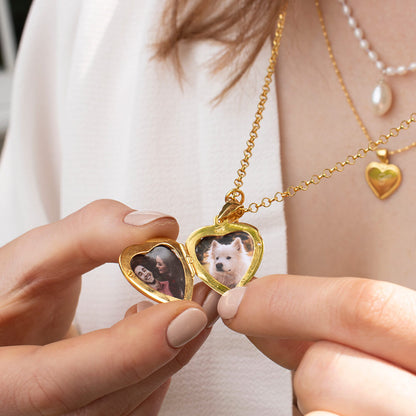 close up of model wearing opened heart locket in gold