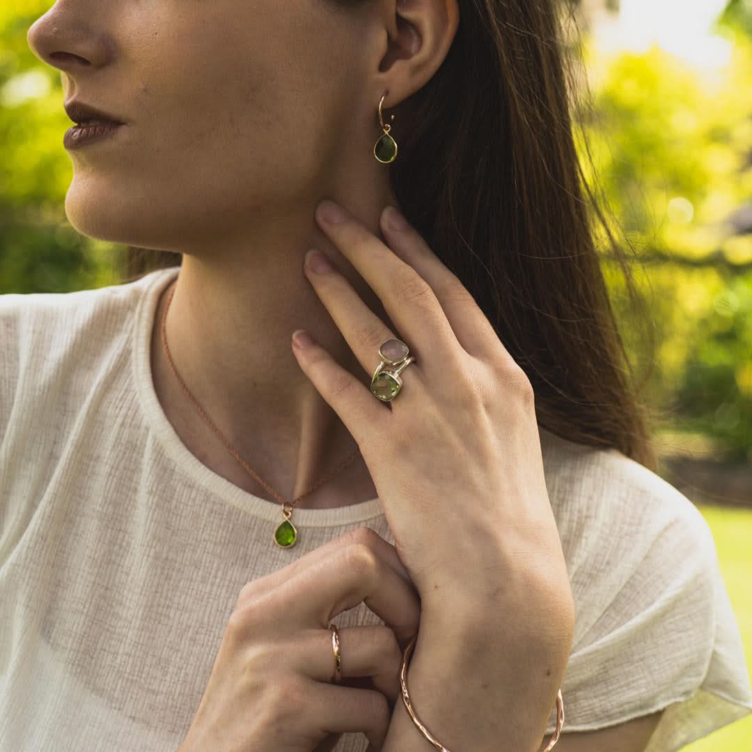 Model wearing peridot drop hoop earrings and matching necklace
