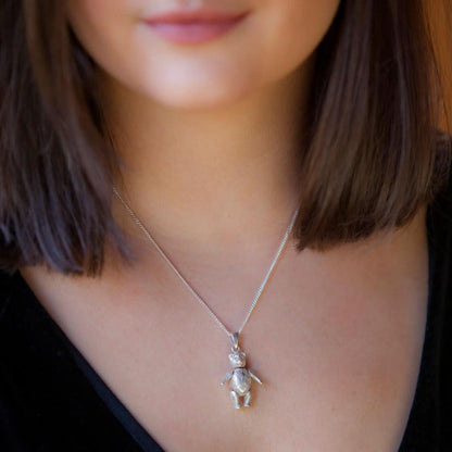 Close up of dark ahired model wearing large sterling silver teddy bear necklace on silver curb chain