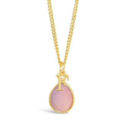 pink opal charm necklace in gold with initial charm on a white background
