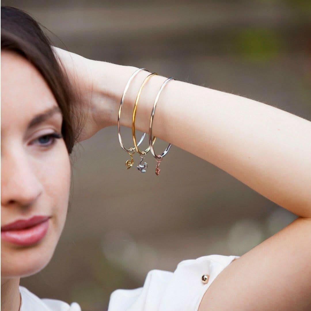 model wearing three bird bangles on her wrist 