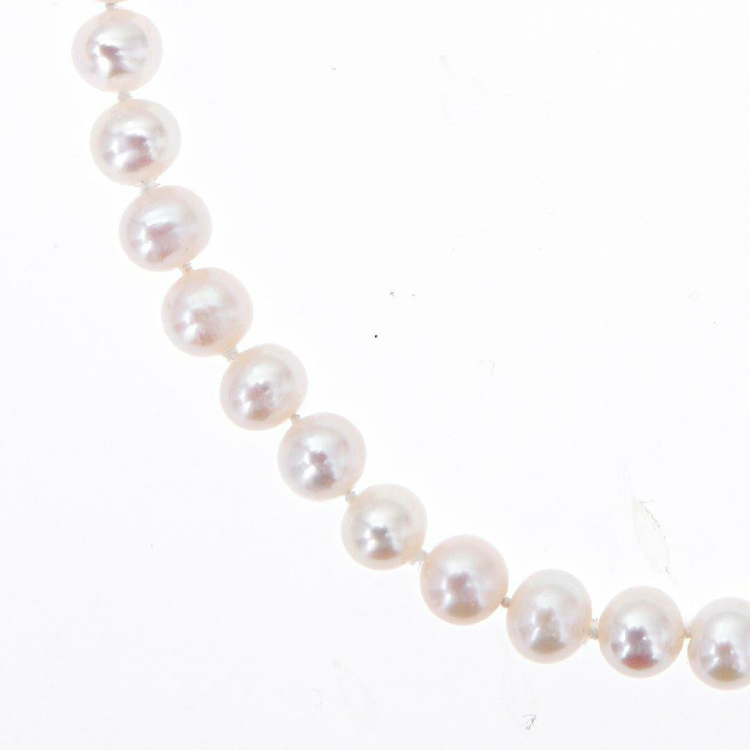 close up of classic pearl necklace in ivory on a white background