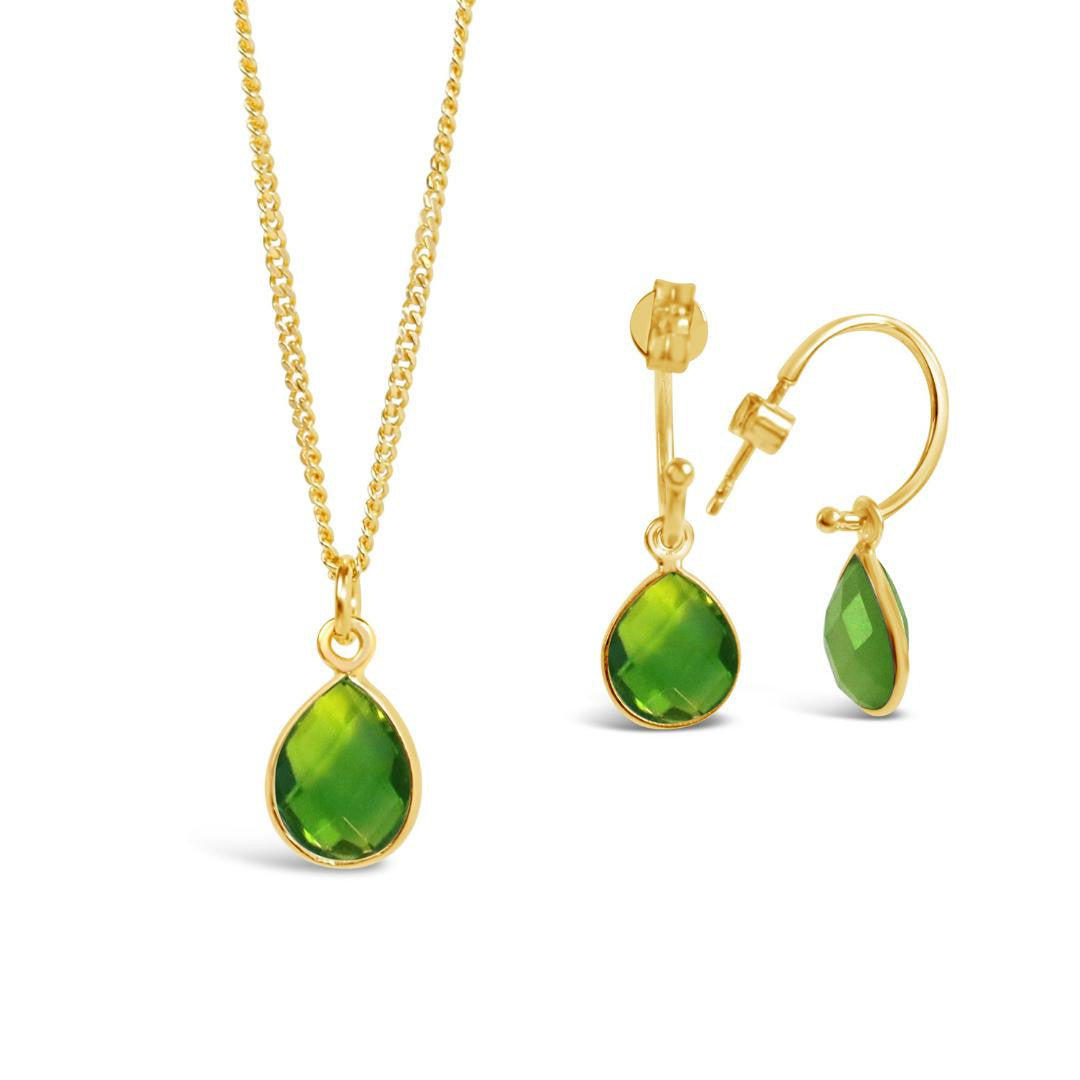 peridot drop hoop earrings in gold with matching necklace on a white background