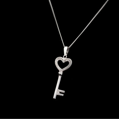 love key pendant in silver on a black background