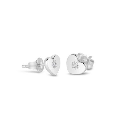 side on view of heart shaped stud style earrings in silver with a diamond decoration a white background