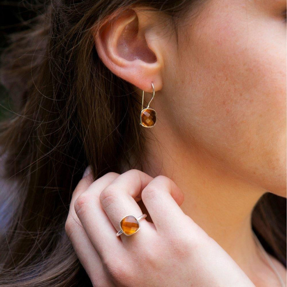close up of model wearing citrine earrings in gold with matching cocktail ring
