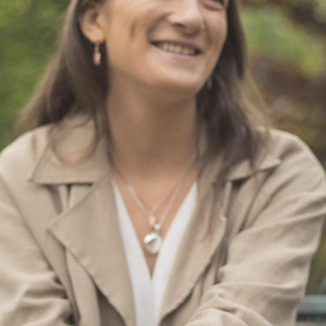 model wearing feather locket in white gold with feather charm