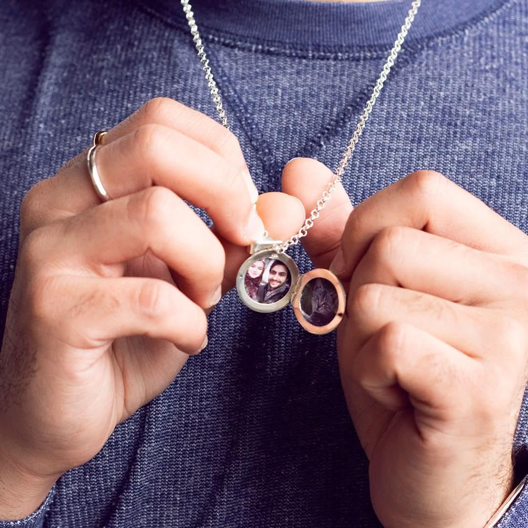 model wearing mens round locket necklace in white gold with photos inside