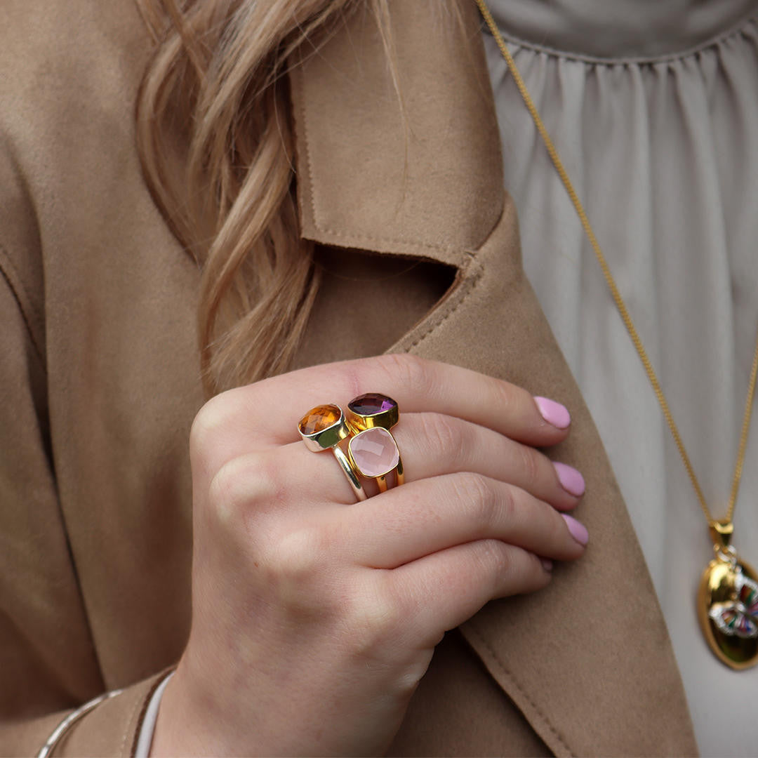 model wearing stack of cocktail rings in gold 