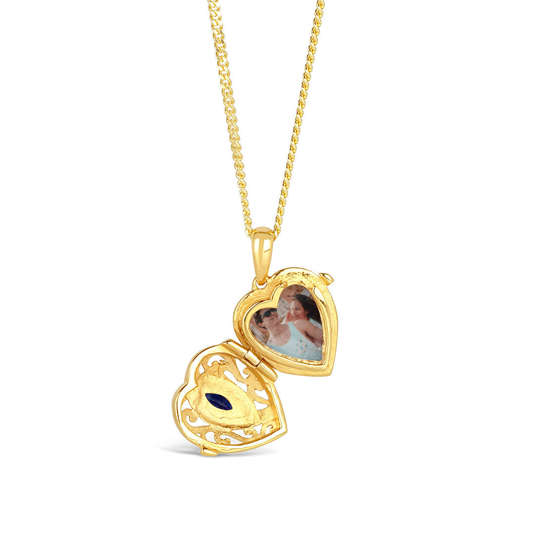 opened sapphire heat locket with family photo inside on a white background