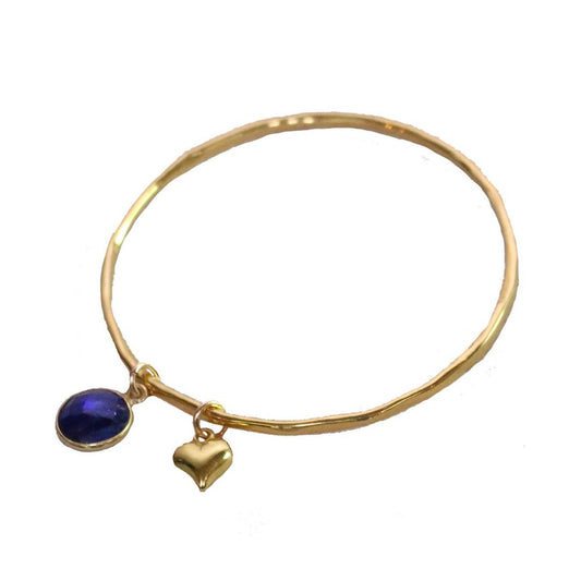 sapphire charm bangle with gold heart on a white background