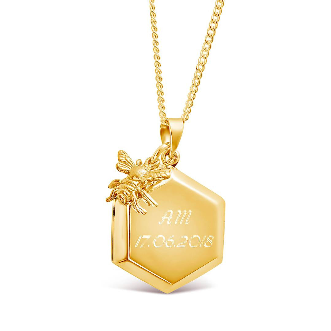 engraved bee locket in gold with gold bee charm attached on a white background