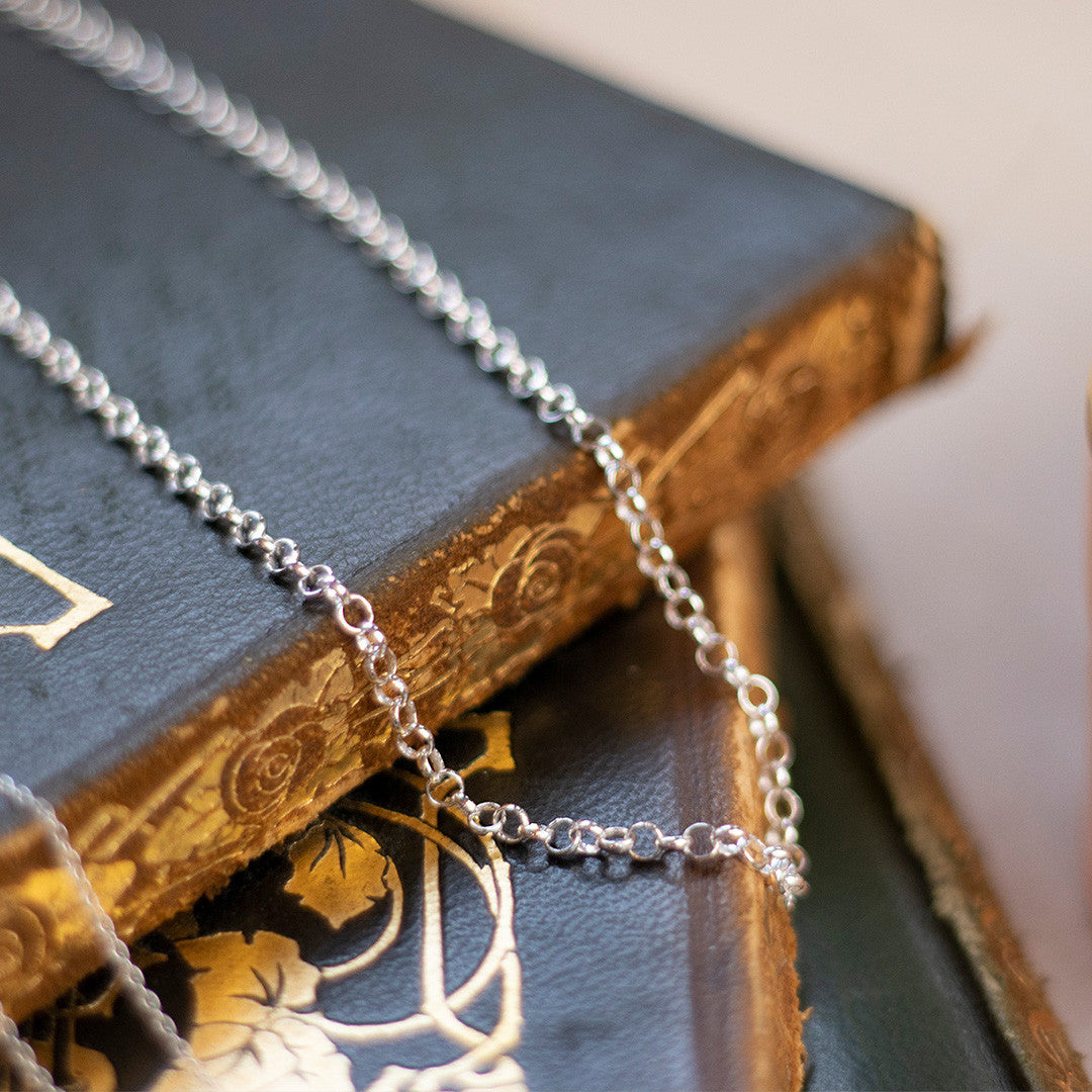 silver belcher chain on top of a book