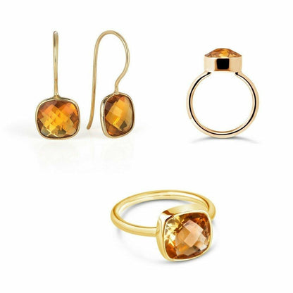 citirne earrings and cocktail ring in gold on a white background
