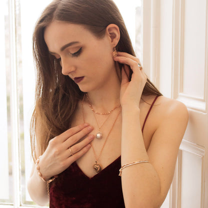 model with rose gold vintage heart locket with garnet gemstone