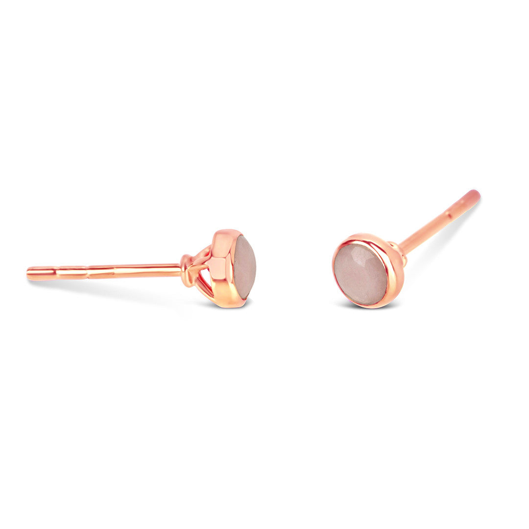 Pink opal mini stud earrings in rose gold facing the side on a white background