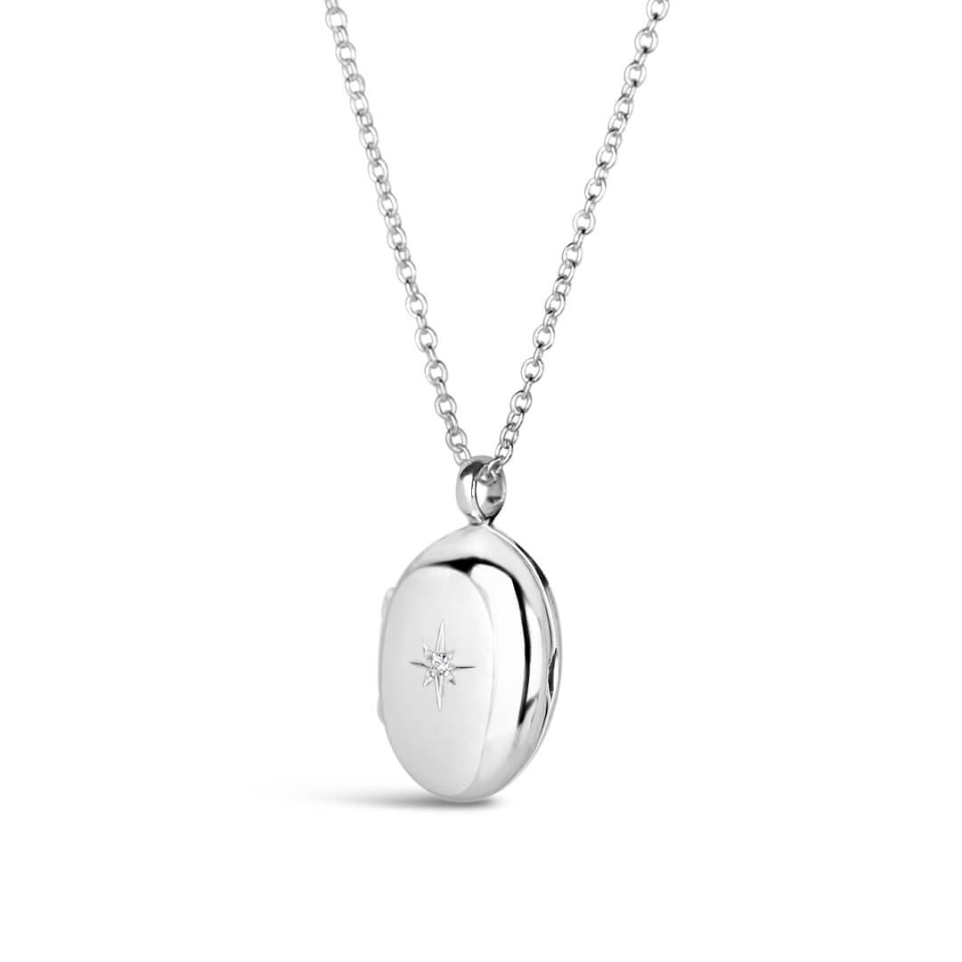 small oval diamond locket in silver on a white background
