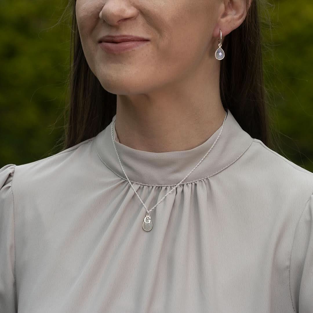 model wearing moonstone drop hoop earrings in silver 