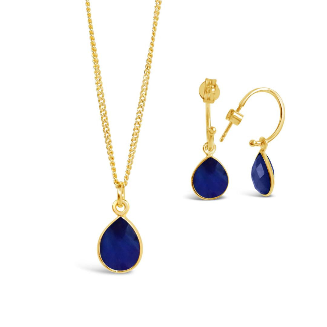sapphire gold necklace and drop hoop earrings on a white background