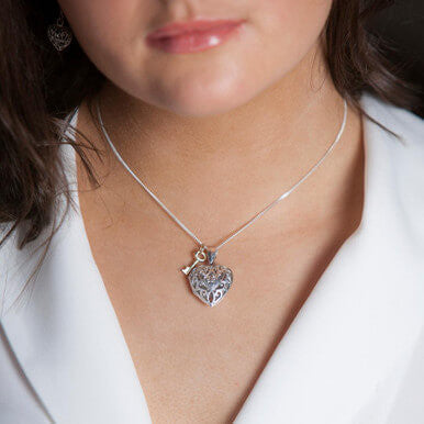 close up of model wearing heart locket necklace in silver 