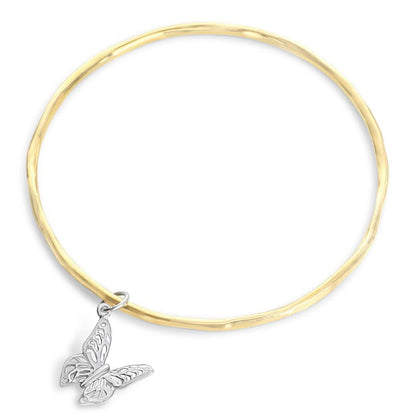 gold bangle with silver butterfly charm on a white background