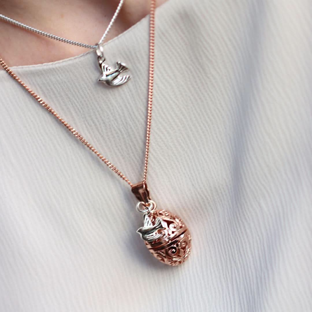 model wearing rose gold bird locket with silver bird charm