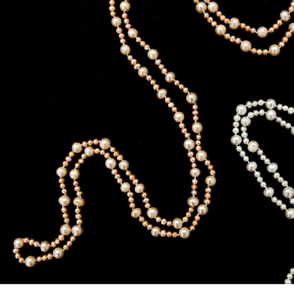 two eternal pearl necklaces on a white background
