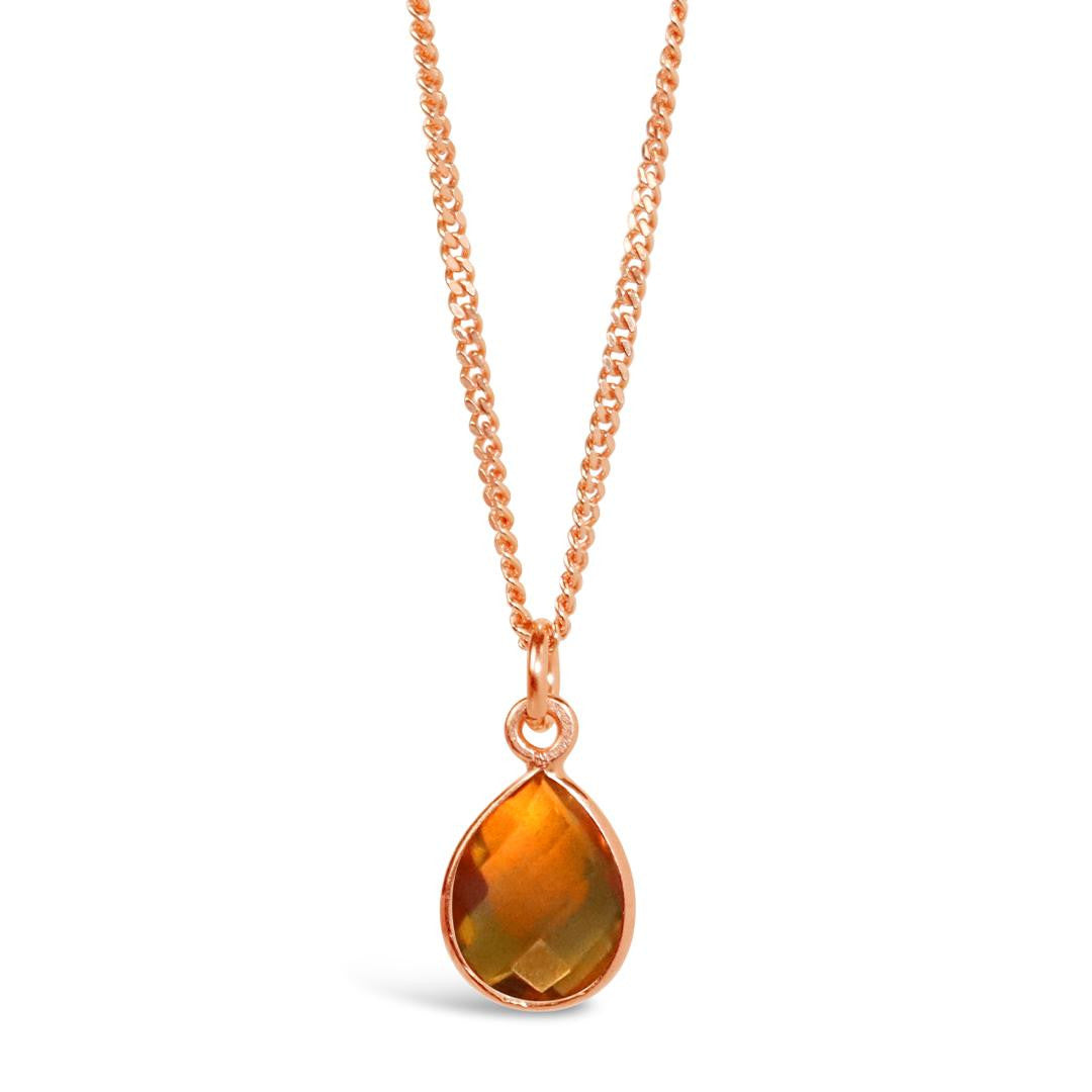 citrine charm necklace in rose gold on a white background