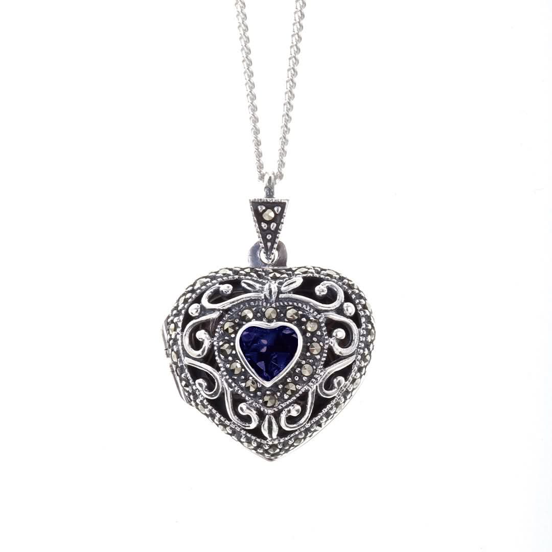 front on view of a sapphire vintage heart locket in white gold on a white background
